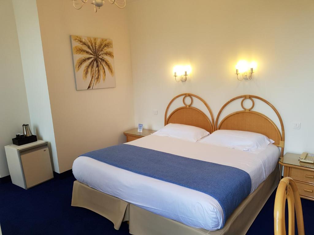 a bedroom with a large bed in a hotel room at Hôtel de Charme Brise Marine in Saint-Jean-Cap-Ferrat