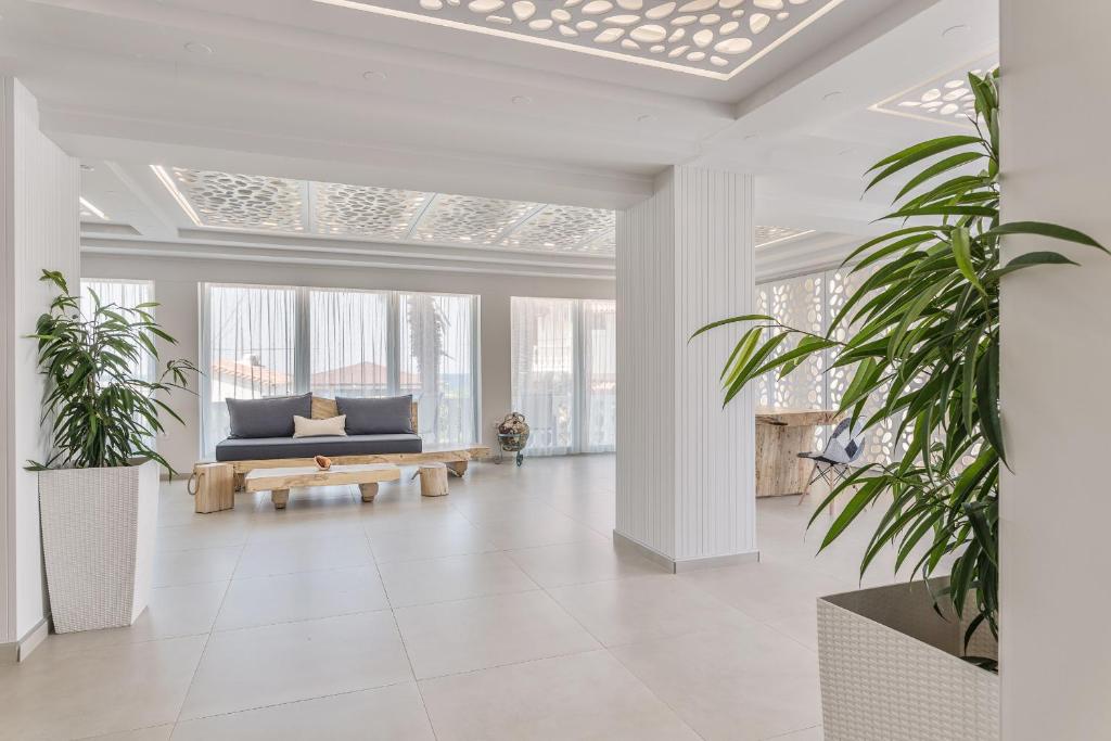 a living room with a couch and potted plants at Kokkari Beach Hotel in Kokkari