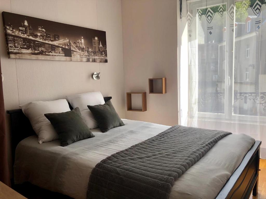 1 dormitorio con 1 cama grande y ventana grande en Residence Soleil des Thermes 2, en Le Mont-Dore