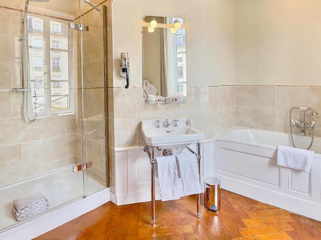 a bathroom with a tub and a sink and a shower at Le Tardif, Noble Guesthouse in Bayeux