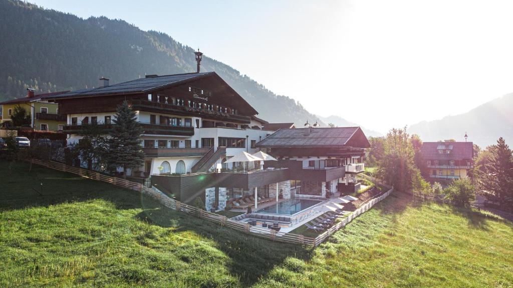 a large building on top of a grass field at Sonnhof by Vitus Winkler in Sankt Veit im Pongau