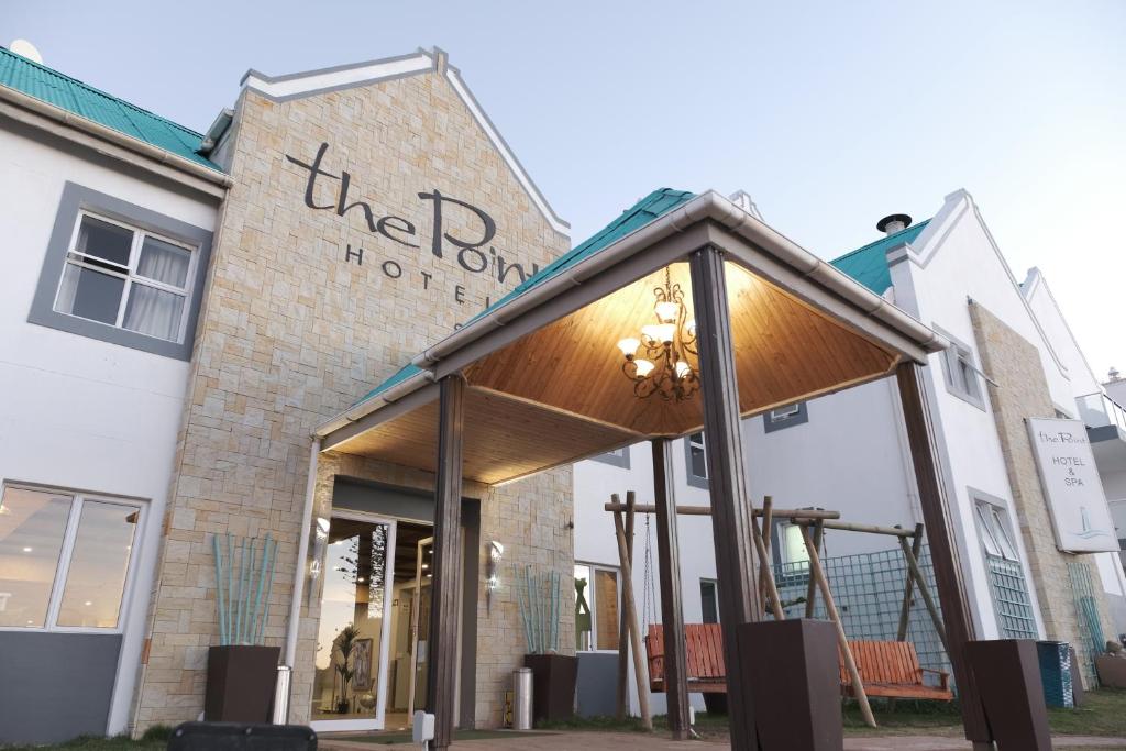 un negozio con tenda da sole di fronte a un edificio di The Point Hotel & Spa a Mossel Bay