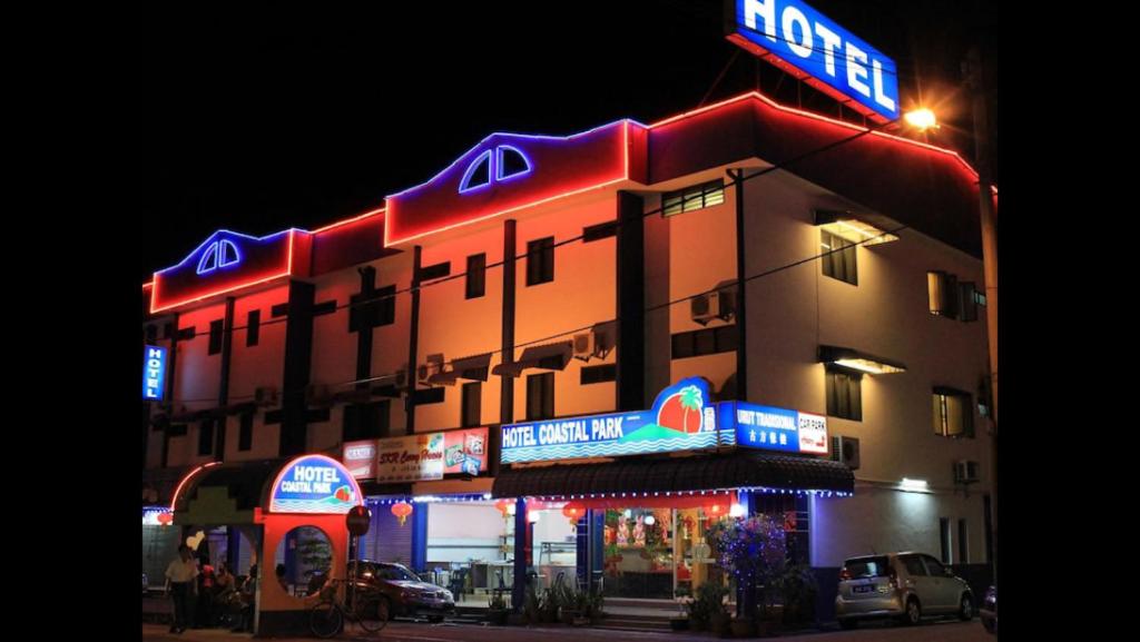 a building with neon signs on the side of it at Coastal Park Hotel in Malacca