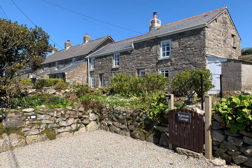 uma casa de pedra com uma cerca de pedra em frente em Bojewyan Cottage, Sandy Beaches and Great walking em Penzance