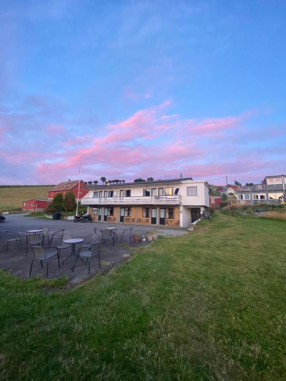 a group of tables and chairs in front of a building at Solvang Ferietun in Vangsnes