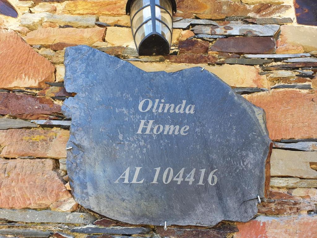 una señal de piedra en el costado de una pared de ladrillo en Olinda Home, en Casas Figueiras
