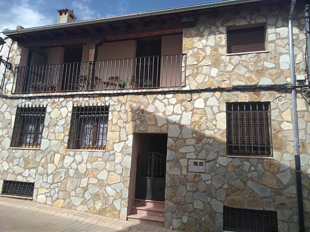 un edificio de piedra con un balcón en un lateral. en Casa en Fuentenebro Ribera del Duero Burgos en Fuentenebro