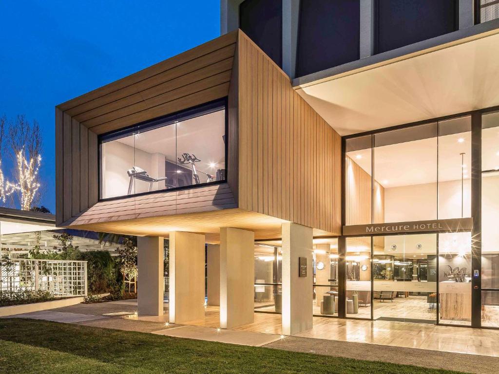 uma casa moderna com uma grande fachada de vidro em Mercure Sydney Rouse Hill em Kellyville