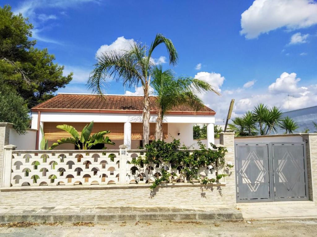 a white fence with a gate in front of a house at Vacanze Porto Cesareo Salento in Torre Lapillo