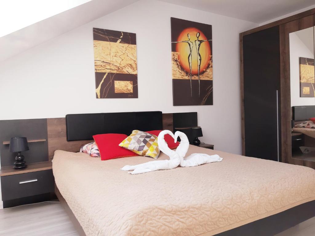 a bedroom with a bed with two swans on it at Apartamenty Asis in Darłówko