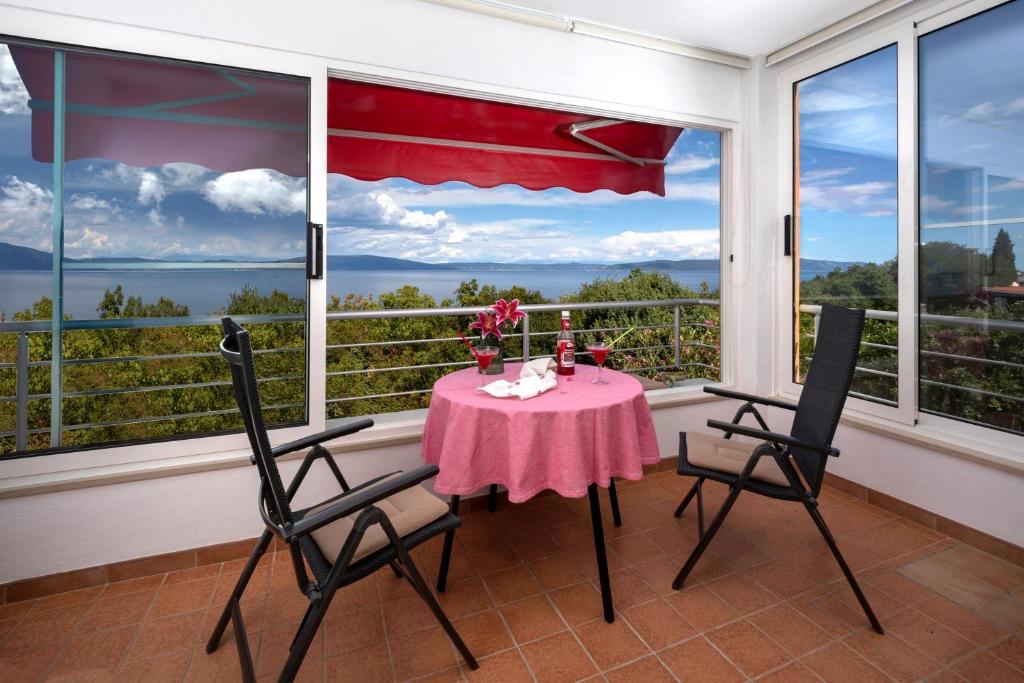 a table and two chairs in a room with a window at B Apartment in Ravni