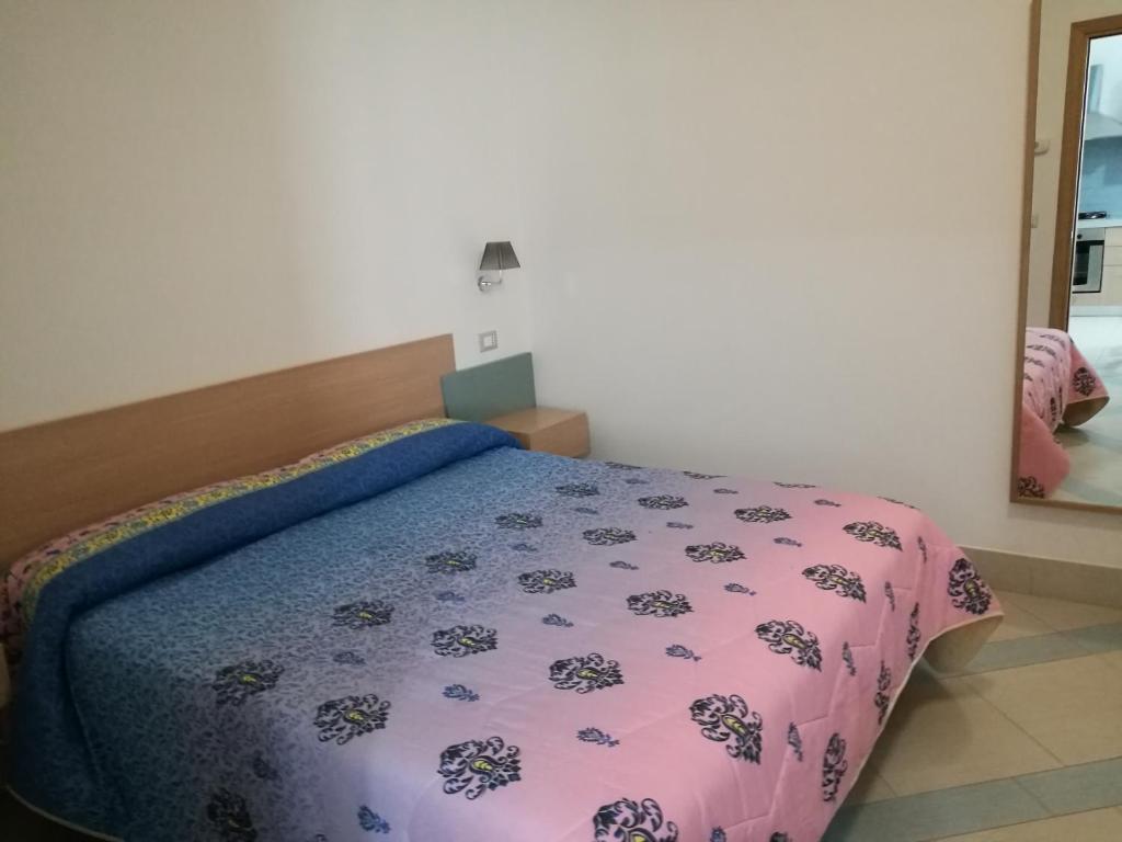 a bedroom with a bed with a purple comforter at Masseria Asciano in Ostuni