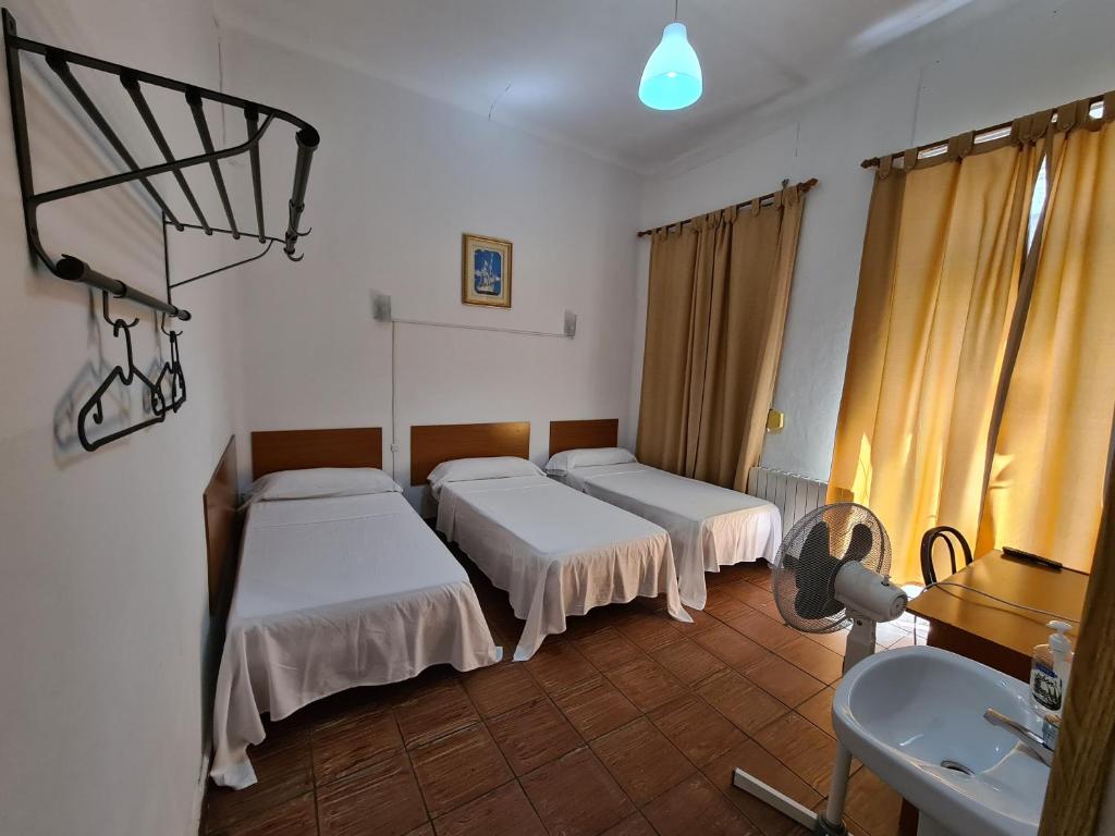 ein Krankenhauszimmer mit 2 Betten und einem Waschbecken in der Unterkunft Pensión Berti Madrid in Madrid