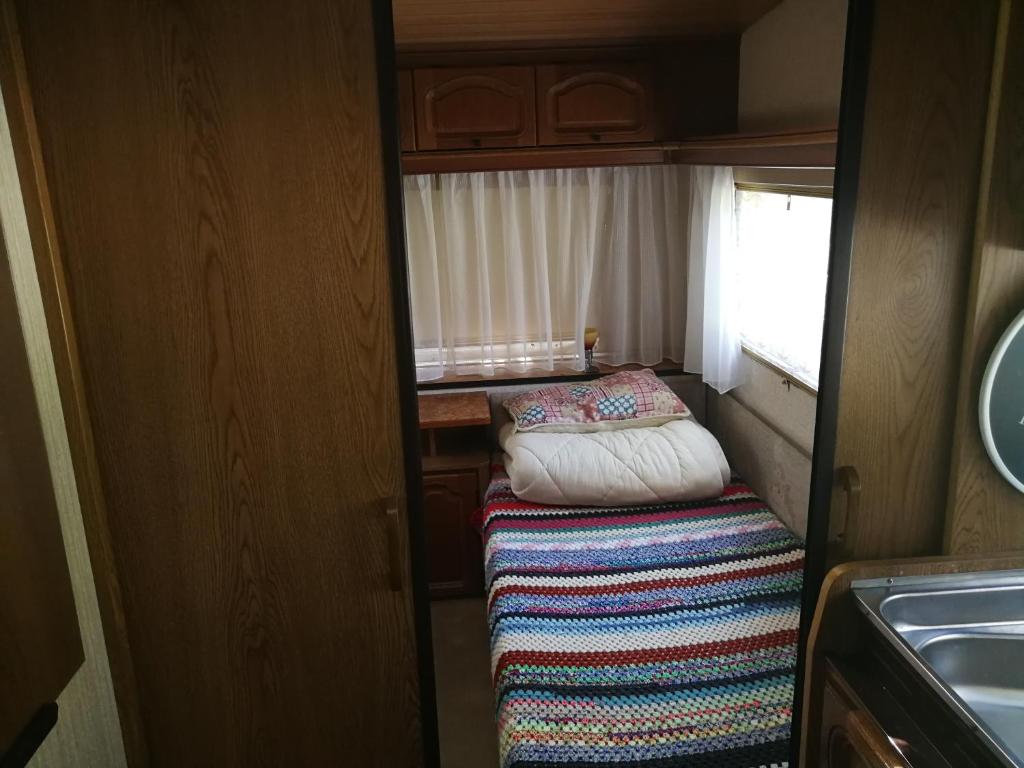 Habitación pequeña con cama y alfombra. en Őrségi Nomád-Lak Nomád 2, en Kercaszomor