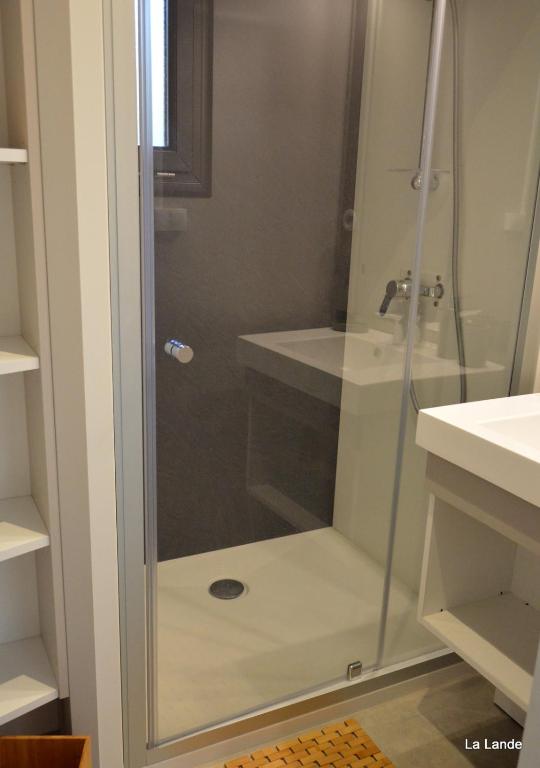 a shower with a glass door in a bathroom at Chalet la lande in Ondres