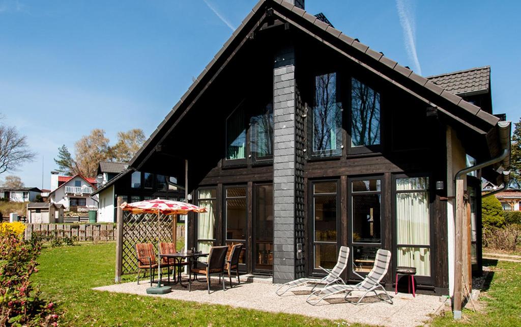una casa con mesa, sillas y sombrilla en Ferienhaus Plau am See in Wassernähe en Plau am See