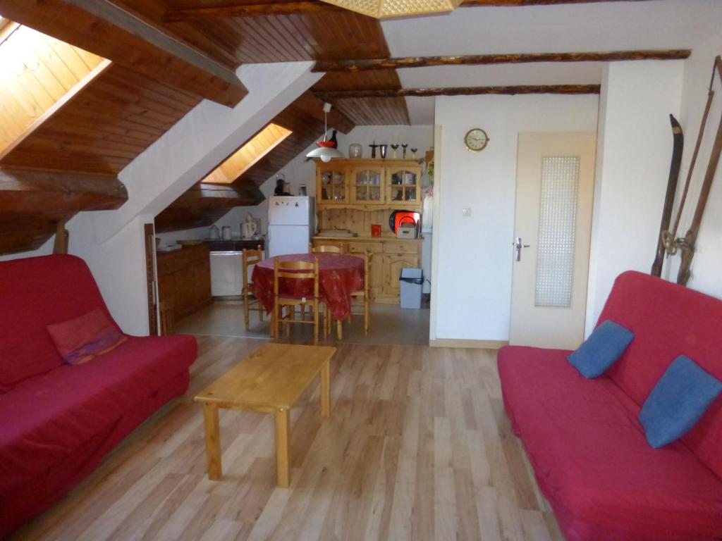 a living room with a red couch and a table at SOLEIL DU SAUZE 406 in Enchastrayes