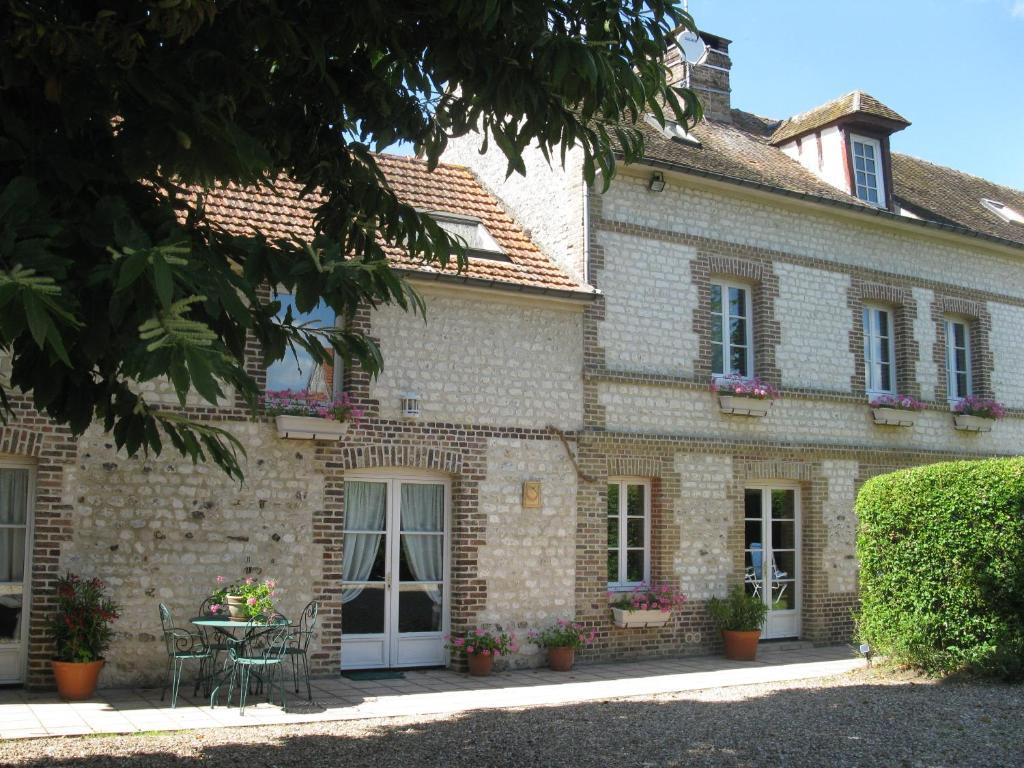 an old stone house with a table in front of it at Les Chambres du Chataignier in Léry