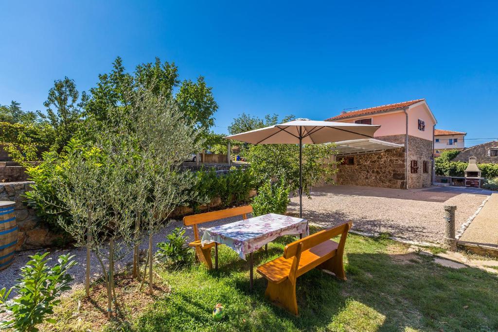 a table with an umbrella and two benches at Holiday Home Vrh in Vrh