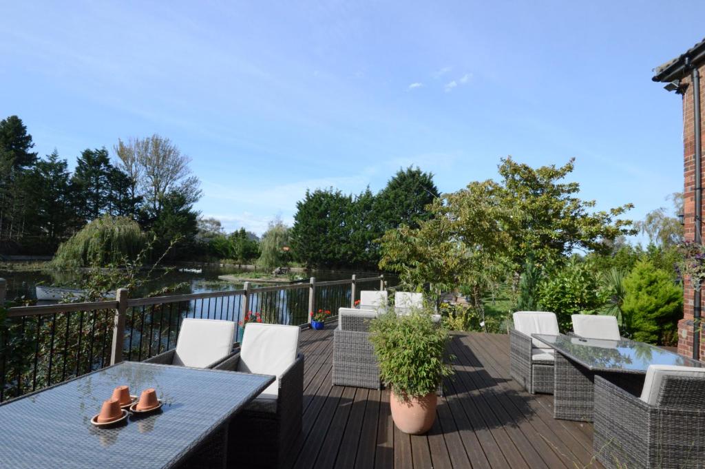 a patio with a table and chairs on a deck at Lakeside Old Hunstanton in Hunstanton