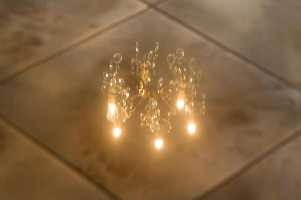 a chandelier with lights on a wooden floor at Hotel Eden in Béthune