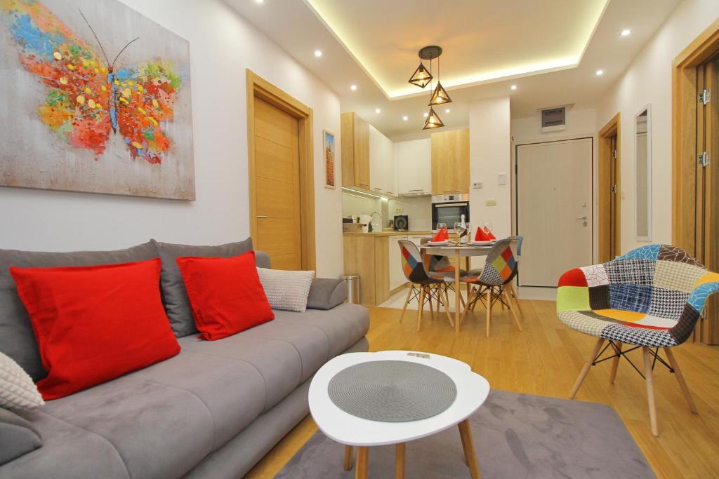 ein Wohnzimmer mit einem Sofa und einem Tisch in der Unterkunft Vila Pekovic green-Apartman PAMA in Zlatibor