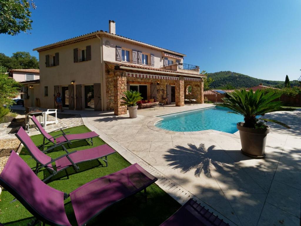 a house with purple lawn chairs and a swimming pool at Villa de charme avec piscine chauffée, Jacuzzi et Sauna in Taradeau