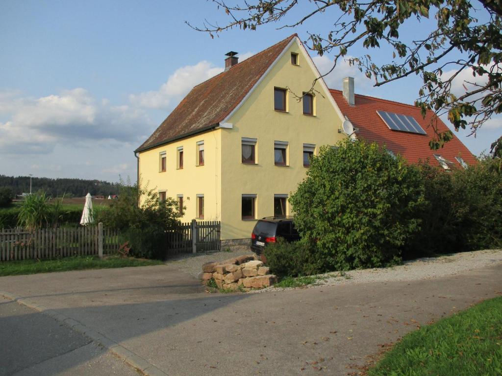 ein weißes Haus mit einem davor geparkt in der Unterkunft Ferienwohnung Rösch in Feuchtwangen