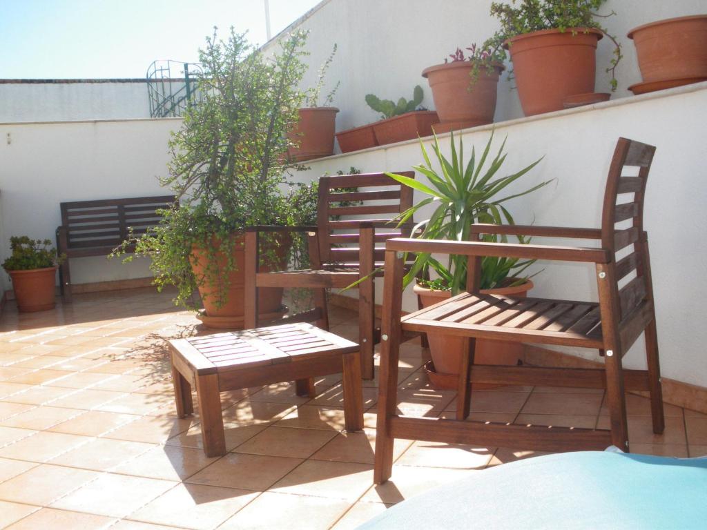 サン・ヴィート・ロ・カーポにあるCASE COLOMBO E MATTARELLA by TreRose Properties - Appartamenti centrali con wi-fi e parcheggio privato gratuitoの植物のあるバルコニー(椅子2脚、テーブル1台付)