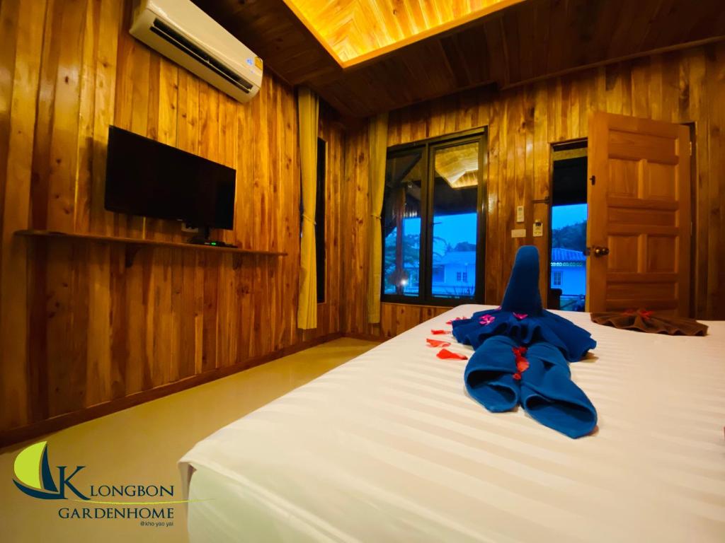 a bedroom with a bed with a blue bow on it at KLONGBON GARDEN HOME Koh Yao Yai in Ko Yao Yai