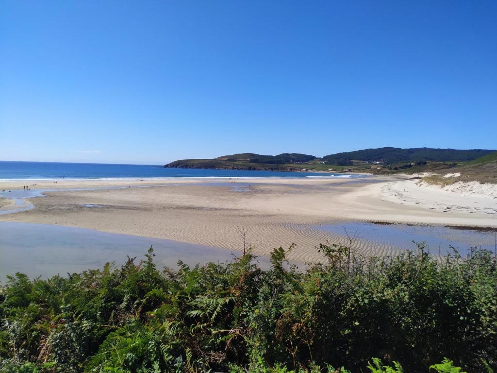 plaża z ludźmi na piasku i wodzie w obiekcie CASA BUITURON w mieście Cee