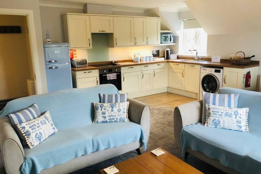 a living room with two chairs and a kitchen at Harbour View is the Perfect Staycation in Whitby