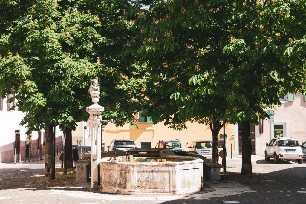 una fuente en medio de una calle con árboles en B&B Alessandro, en Villa Lagarina