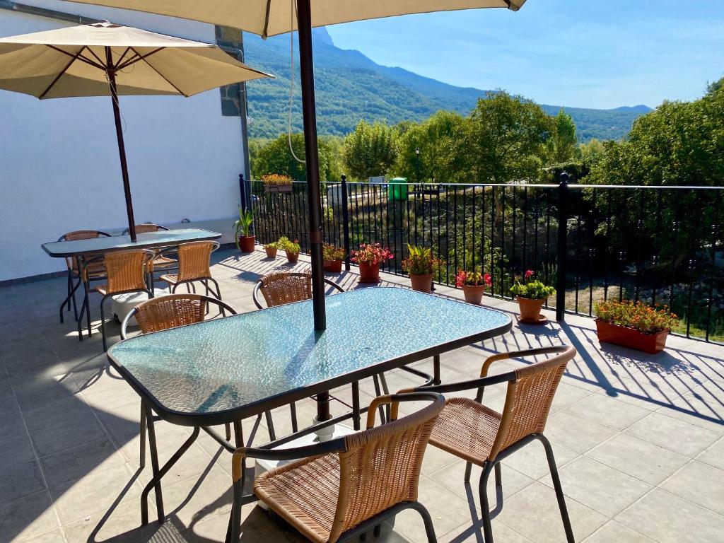 Una mesa y sillas con una sombrilla en un patio. en Hostal Casa Vispe, en Escalona