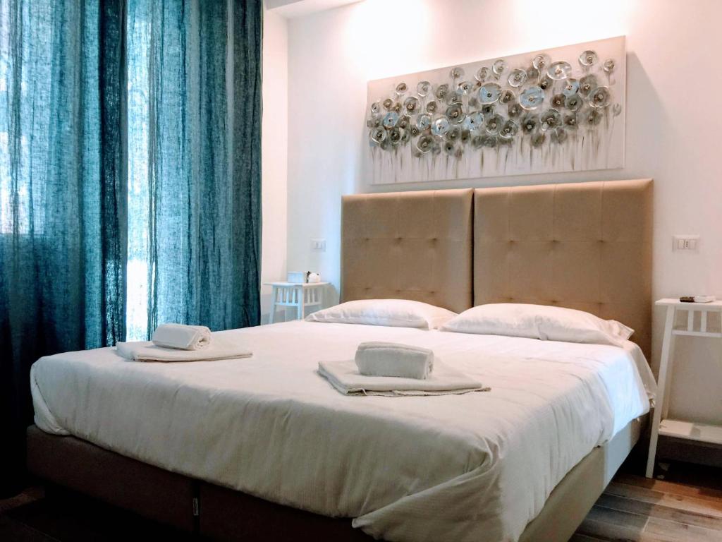 - une chambre avec un grand lit, des serviettes et des assiettes dans l'établissement Pigneto Guest House, à Rome