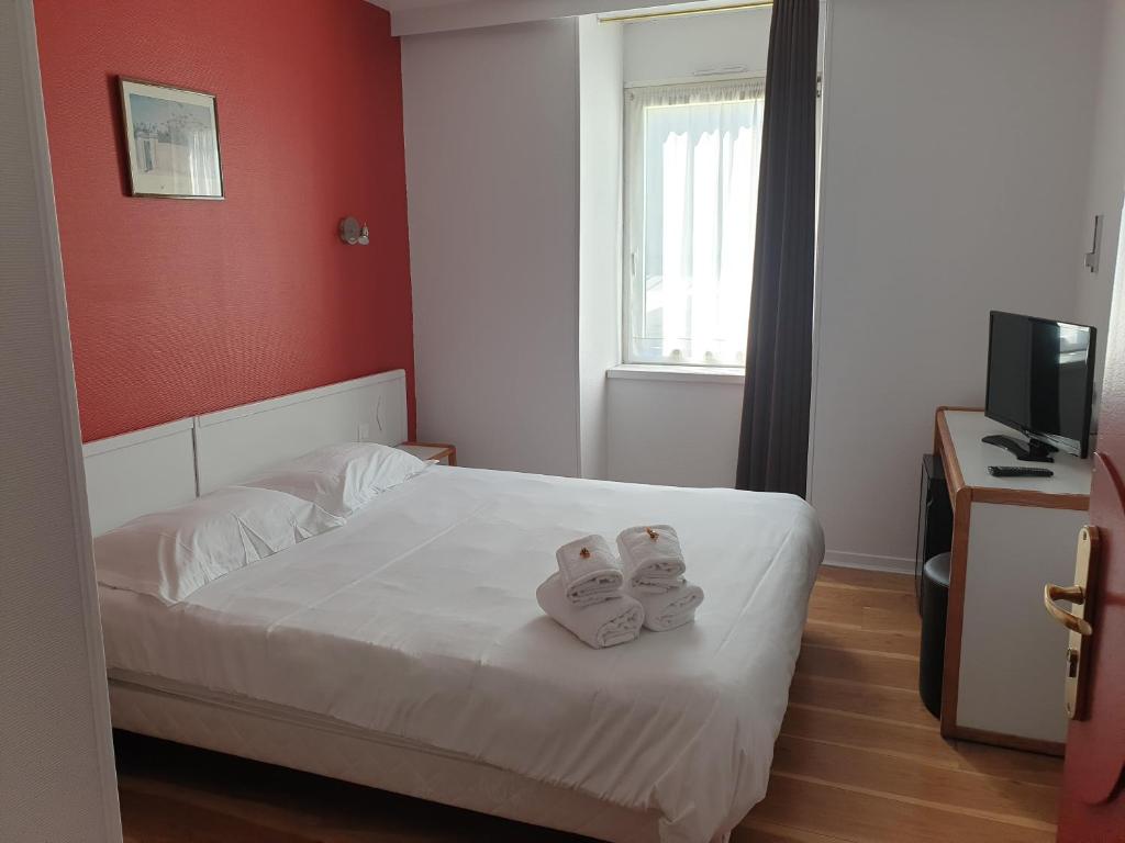 a bedroom with a bed with two towels on it at Hôtel Hermance in Bellegarde-sur-Valserine