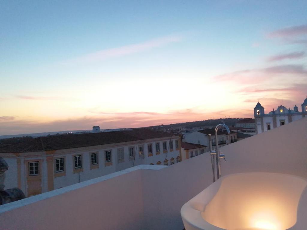 una vasca da bagno sul tetto di un edificio con il tramonto di Evora Inn a Évora