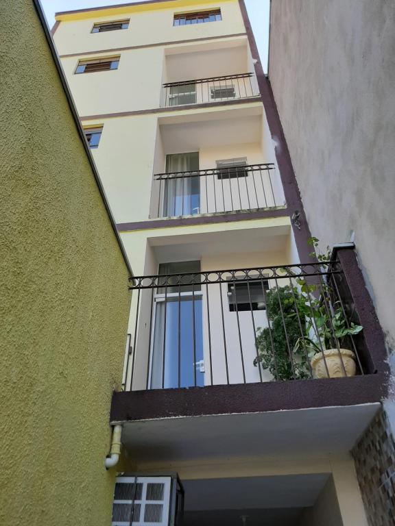 an apartment building with a balcony with plants on it at Pousada Pena in Aparecida