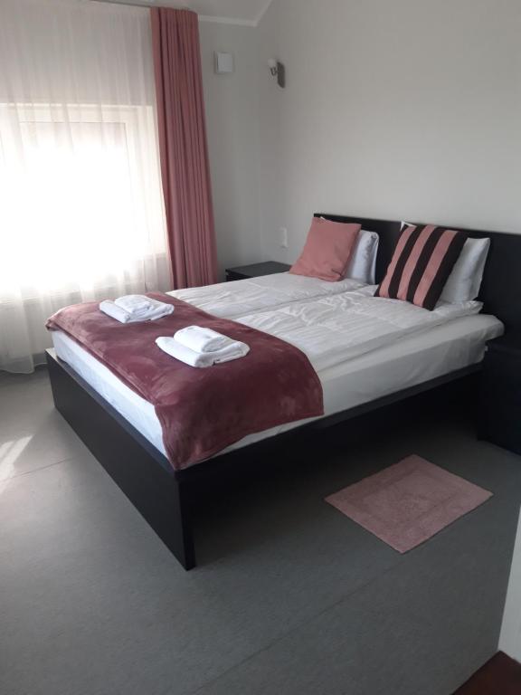 uma cama grande num quarto com uma janela em Jaunāmuiža Apartamenti em Valmiera