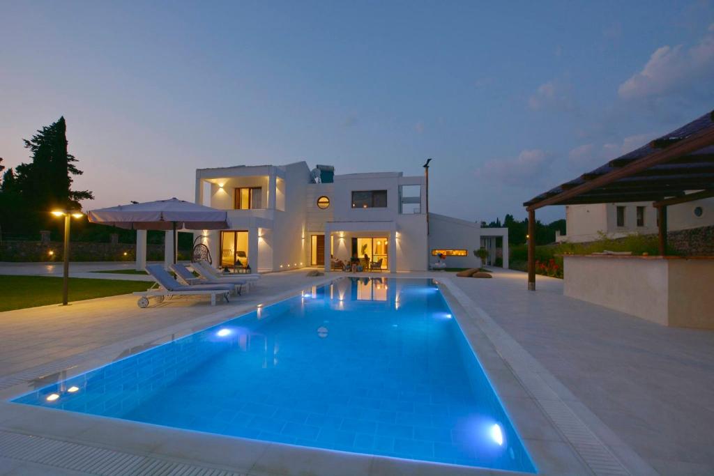 uma villa com piscina em frente a uma casa em Sunlight Eros Villa em Áfra