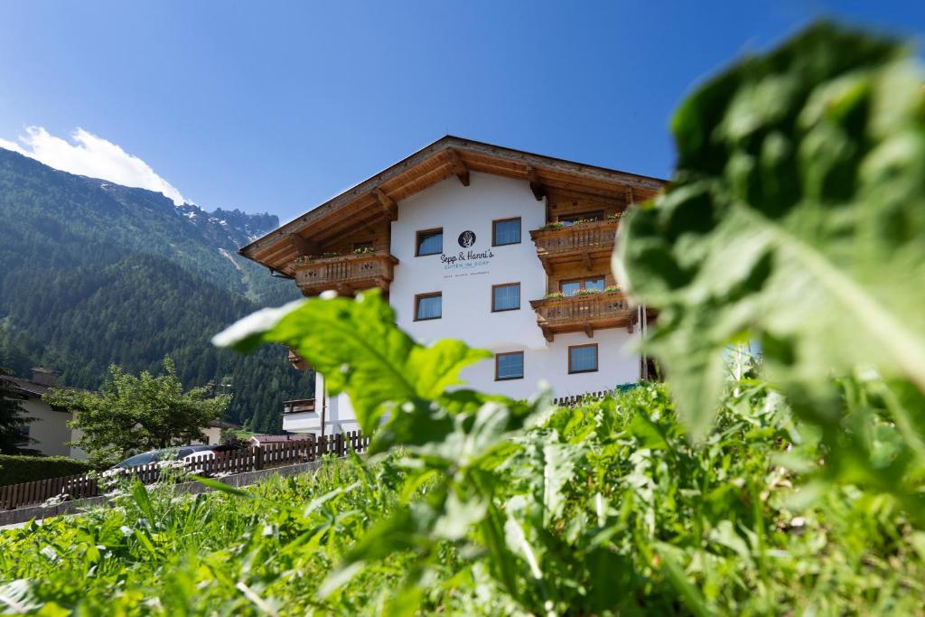 ein Gebäude mit Balkon auf der Seite in der Unterkunft Sepp & Hannis Suiten im Dorf in Neustift im Stubaital