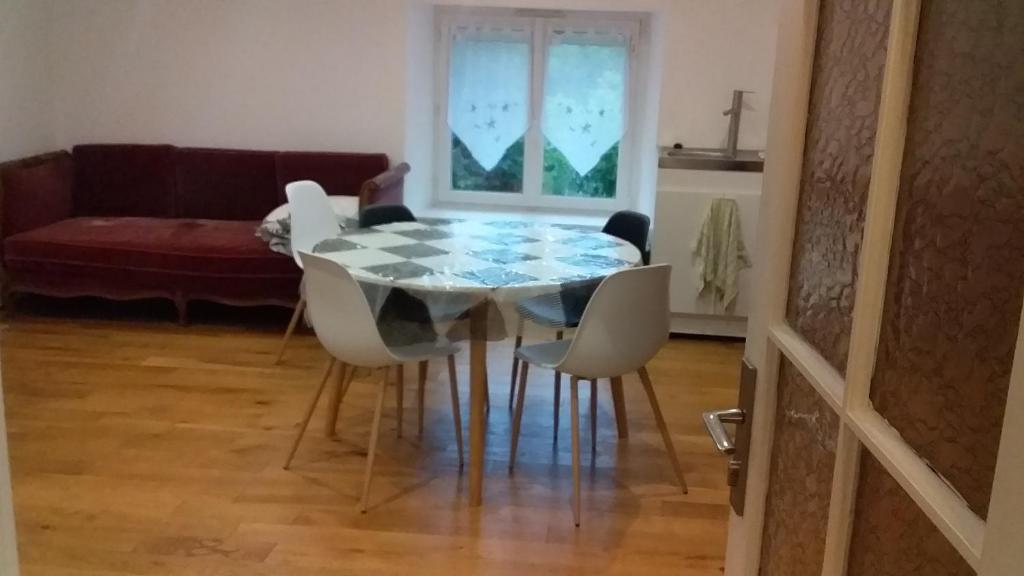 ein Esszimmer mit Glastisch und Stühlen in der Unterkunft Ferme Maya in Saint-Genest-Lerpt