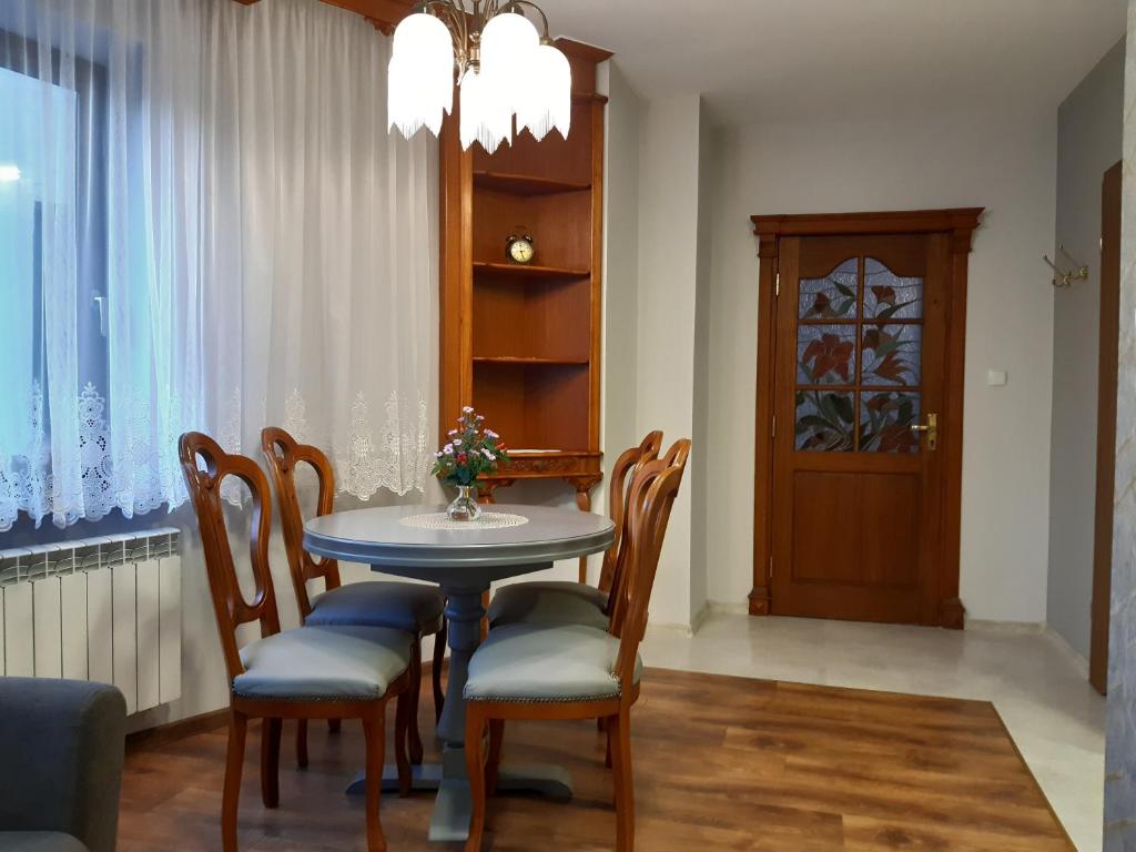 a dining room with a table and chairs and a door at SECESJA HOUSE in Oświęcim