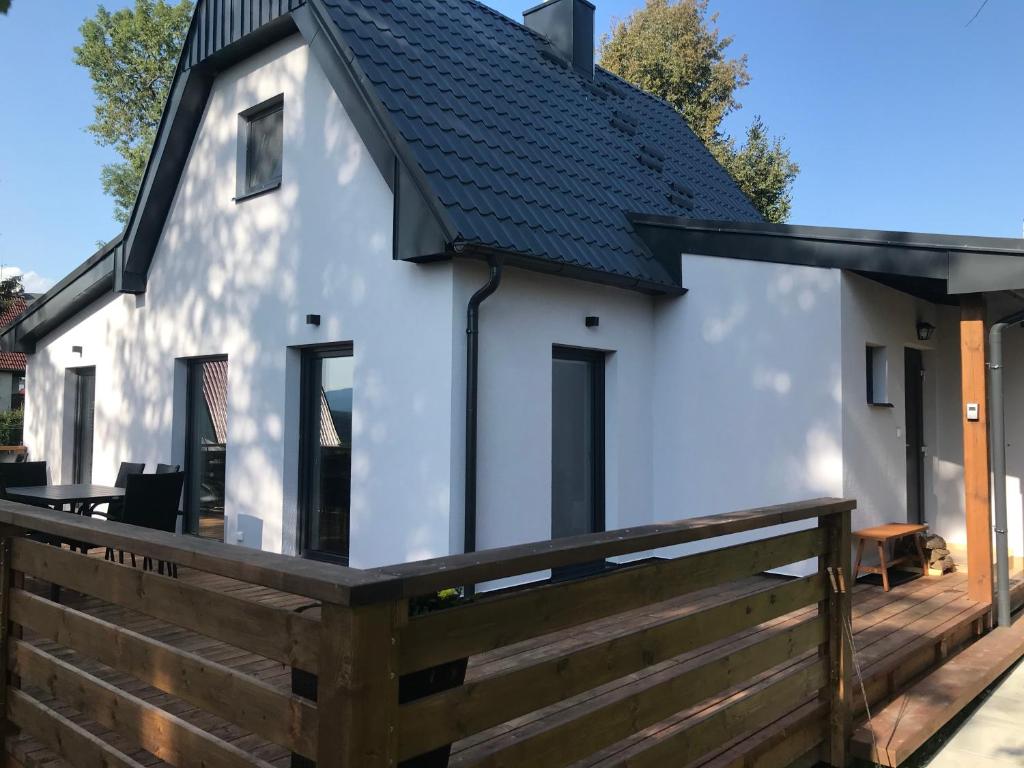 een wit huis met een zwart dak bij Chata Bellis in Černá v Pošumaví