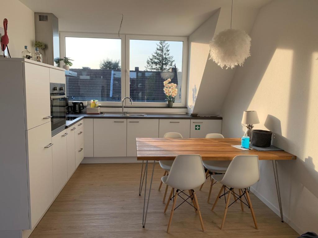 uma cozinha com uma mesa de madeira e armários brancos em Apartment Brander Blick em Aachen