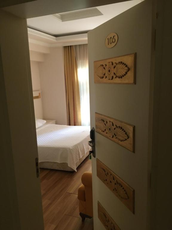 Zimmer mit einem Schlafzimmer mit einem Bett und einer Tür in der Unterkunft Barby Butik Otel in Kemer