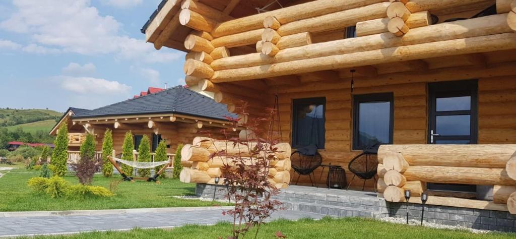 a log house with a hammock in front of it at Resort Back To Nature in Bran