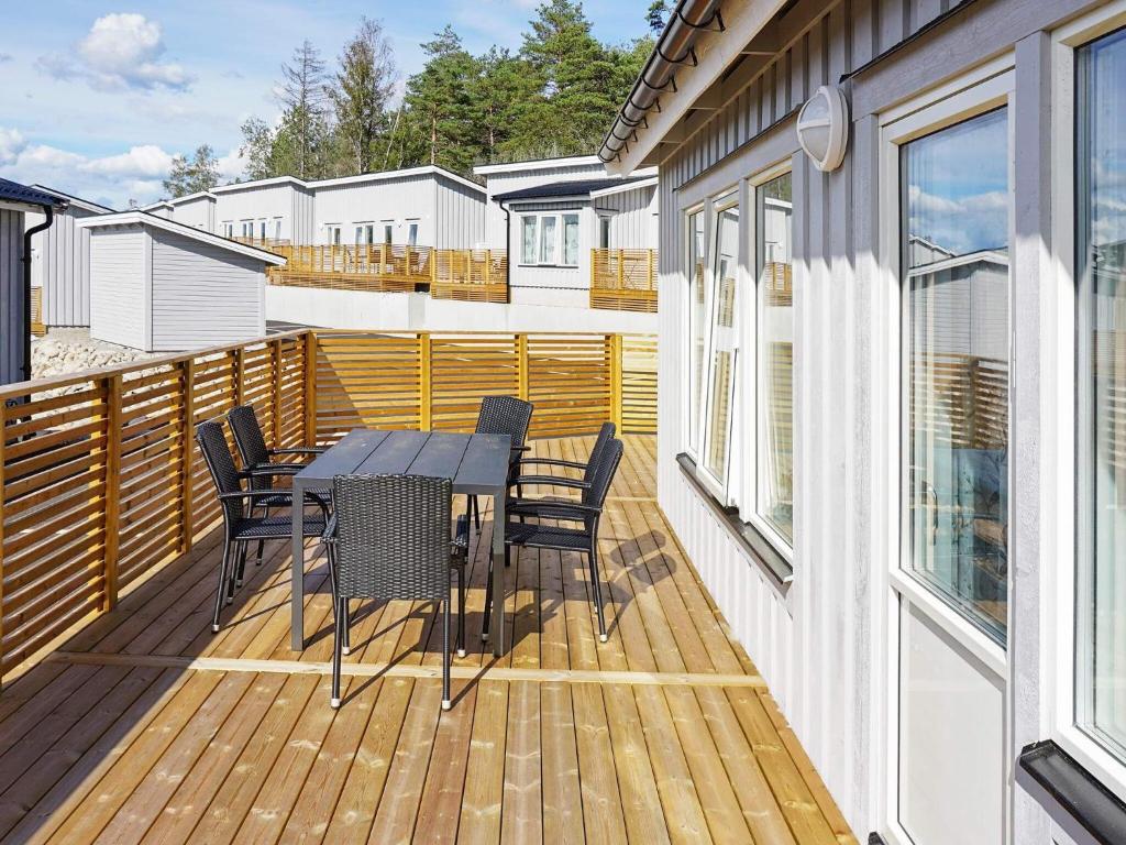 eine Holzterrasse mit einem Tisch und Stühlen darauf in der Unterkunft 6 person holiday home in STR MSTAD in Strömstad