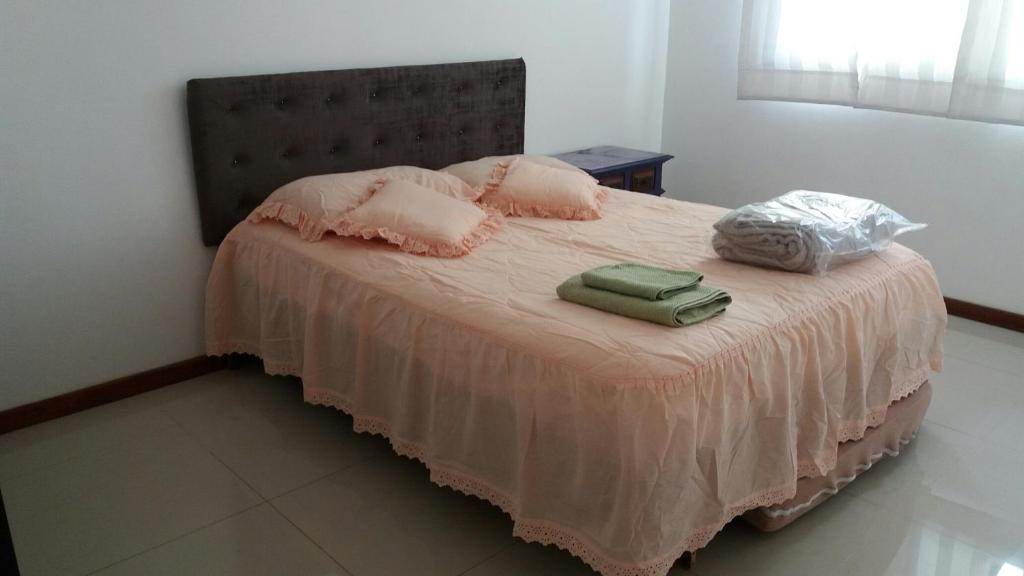 a bedroom with a bed with two bags on it at Solar da Praia in Vitória