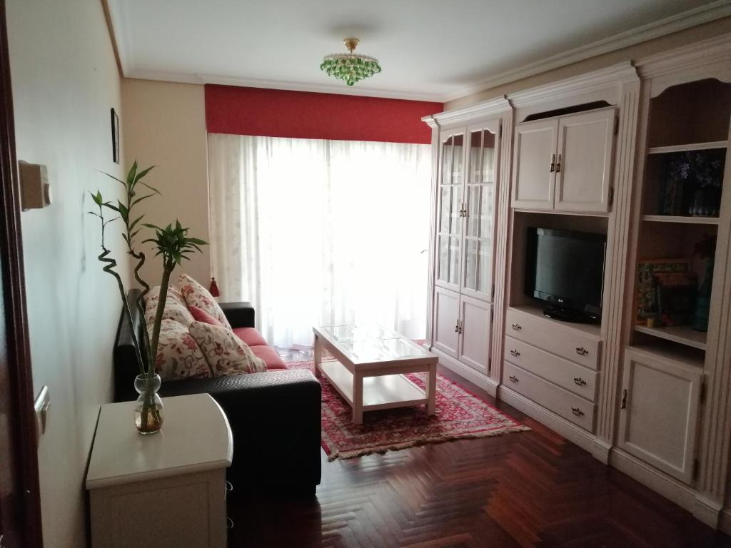 a living room with a couch and a tv at Rotonda da Pedra Alta Apartamento in Cangas de Morrazo